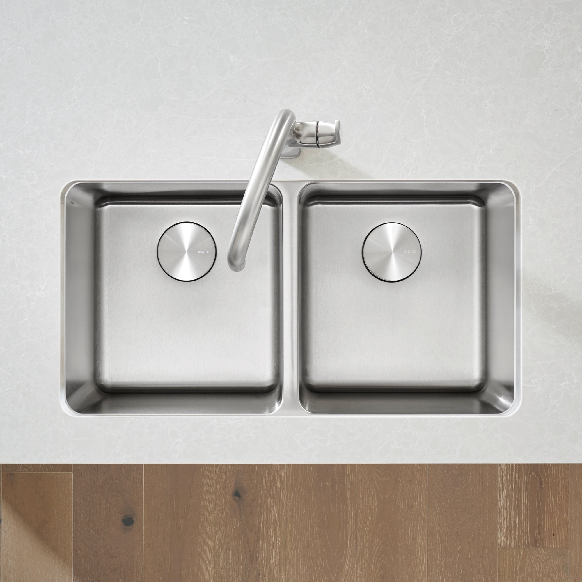 Stainless steel double bowl undermount kitchen sink with two equal square basins and chrome faucet mounted on white counterto