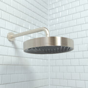 Brushed nickel round shower head with curved arm mounted on white subway tile wall.