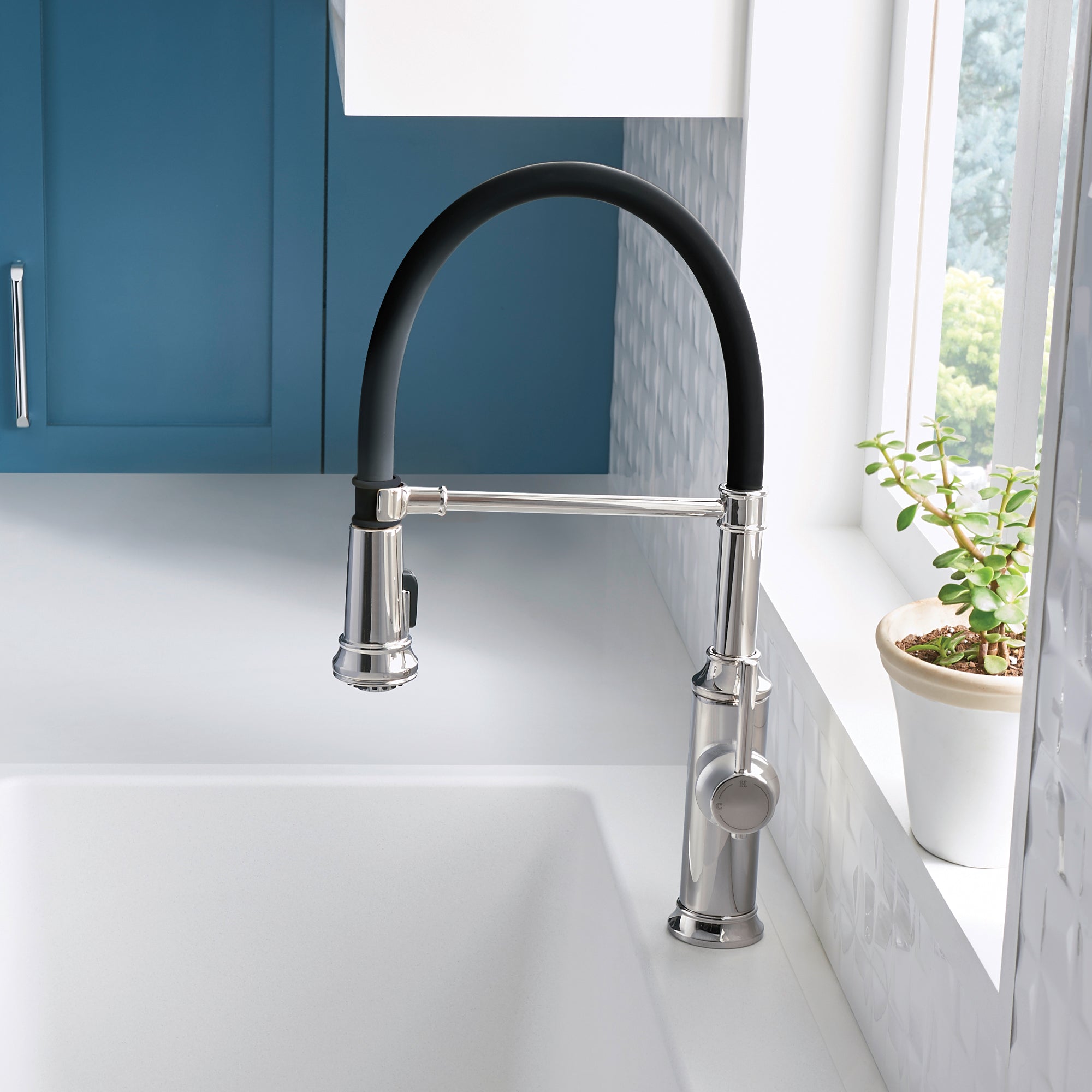 Stainless steel semi-pro kitchen faucet with black pull-down spray head and curved arc spout above white sink.