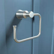 Brushed nickel towel ring with cylindrical wall mount and open rectangular loop design mounted on blue wall.