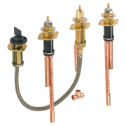 Four brass valve bodies with copper supply lines and black shutoff handles for Roman tub installation.