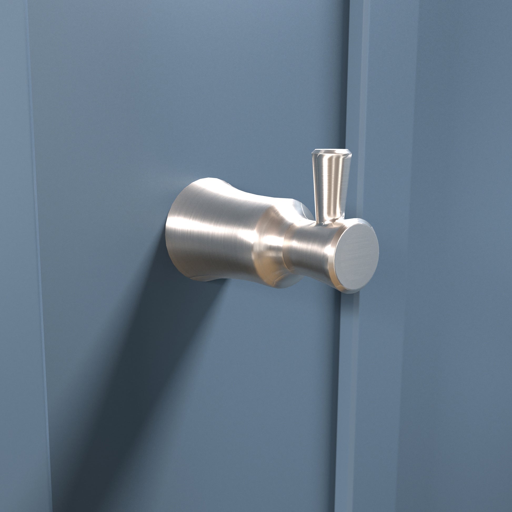 Brushed nickel wall-mounted hook with curved cylindrical design and vertical arm extension mounted on blue wall.