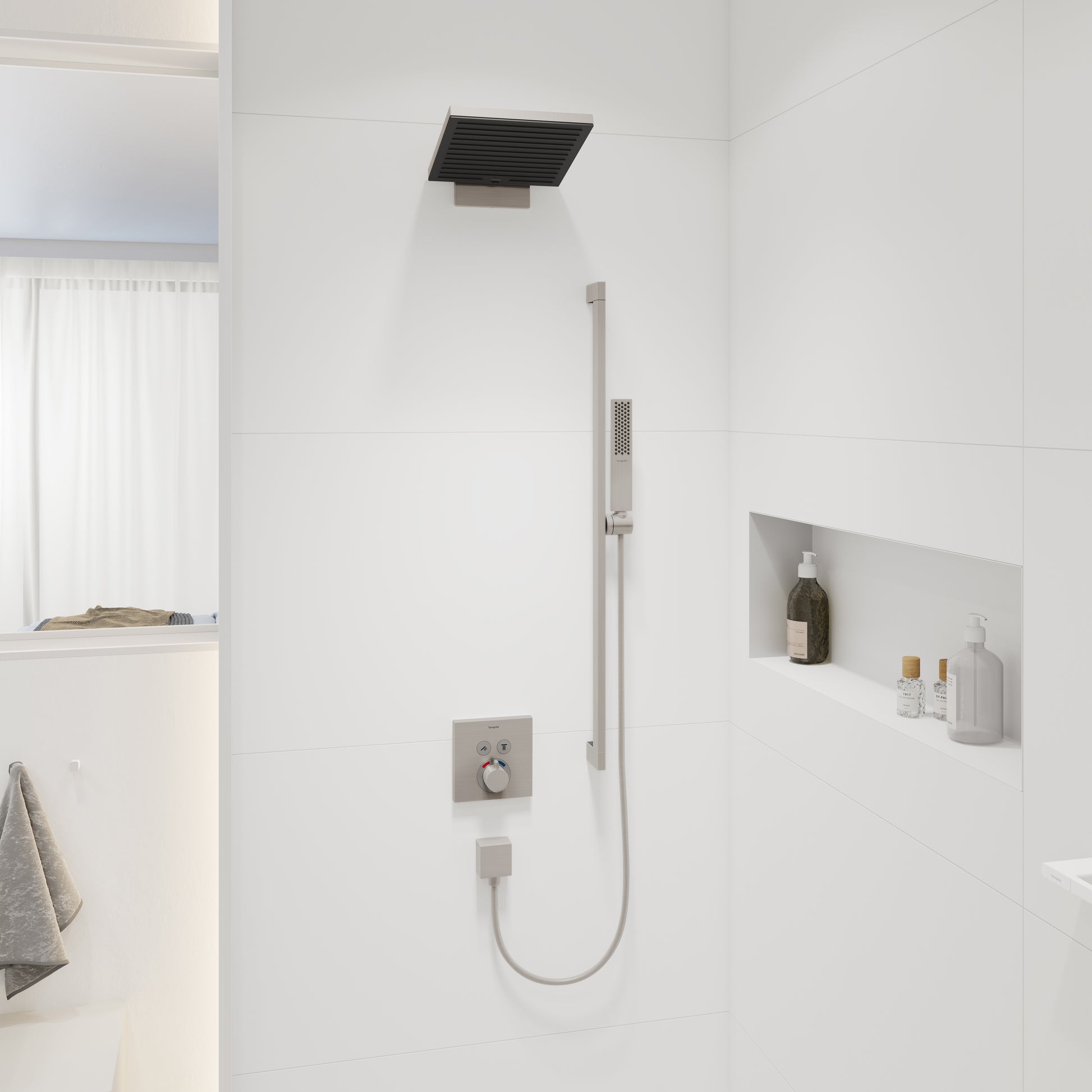 Rectangular brushed nickel shower head mounted on ceiling above white tile shower wall with valve controls.
