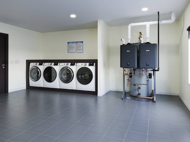 Two dark blue Rinnai hybrid water heaters mounted on wall with white pipes and brass fittings in laundry room setting.
