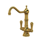 Unlacquered brass two-handle kitchen faucet with curved spout and lever handles on round base.