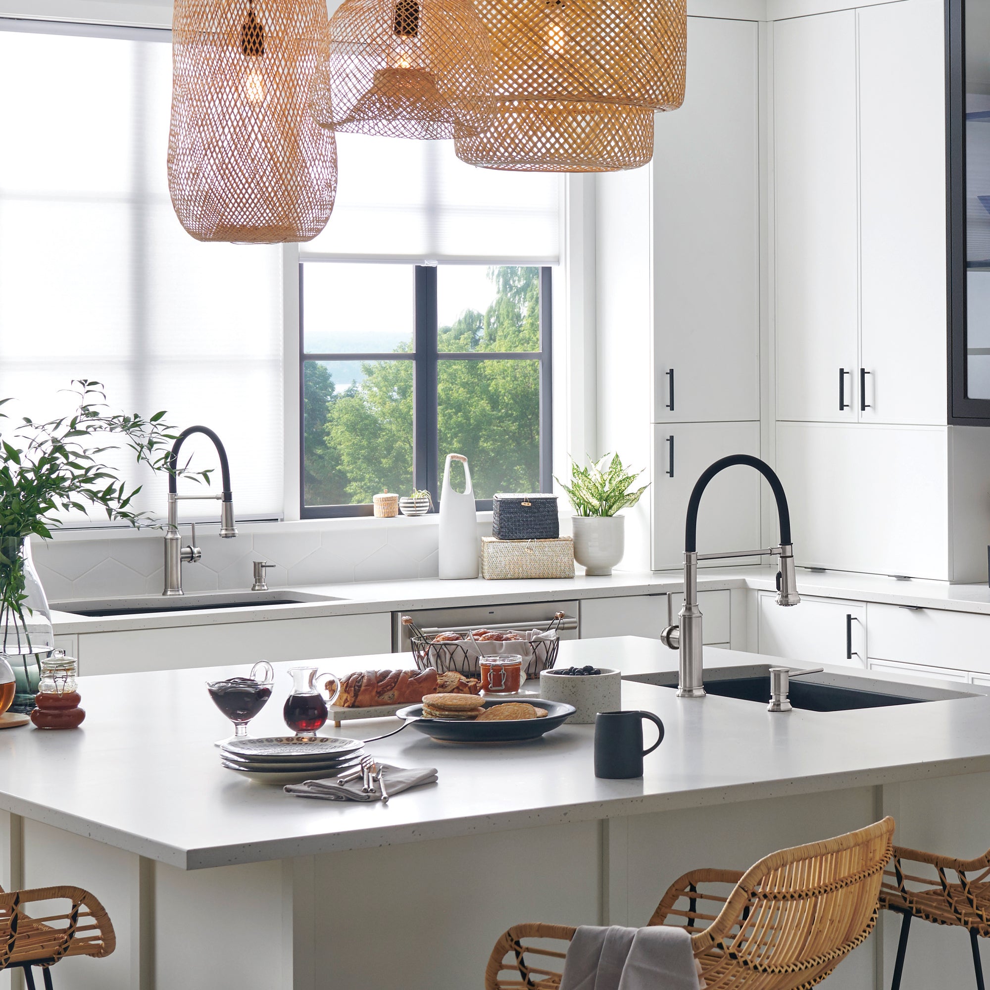 Stainless steel semi-pro kitchen faucet with pull-down sprayer and curved handle mounted on island sink.