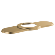 Luxe gold lavatory escutcheon with elongated oval shape and circular opening for faucet installation.
