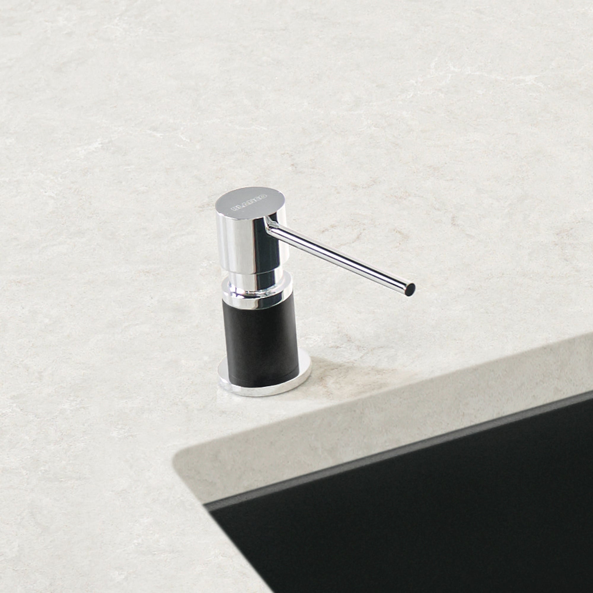 Chrome and coal black soap dispenser with cylindrical pump body and curved spout on light stone countertop.