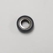 Round black and silver metal shaft seal with hollow center, viewed from above on white background.