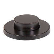 Oil rubbed bronze decorative push button with round raised center and flat base plate.