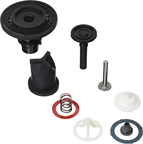Black plastic and metal urinal repair kit components including diaphragm, spring, valve parts, and gaskets.