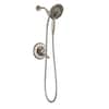 Chrome shower trim with wall-mounted round escutcheon, adjustable hand shower, and hose against white background.