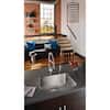 Stainless steel single bowl kitchen sink with faucet mounted in countertop, wood cabinets visible below.