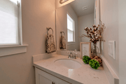 Oval undermount sink with polished chrome faucet installed in marble countertop bathroom vanity.