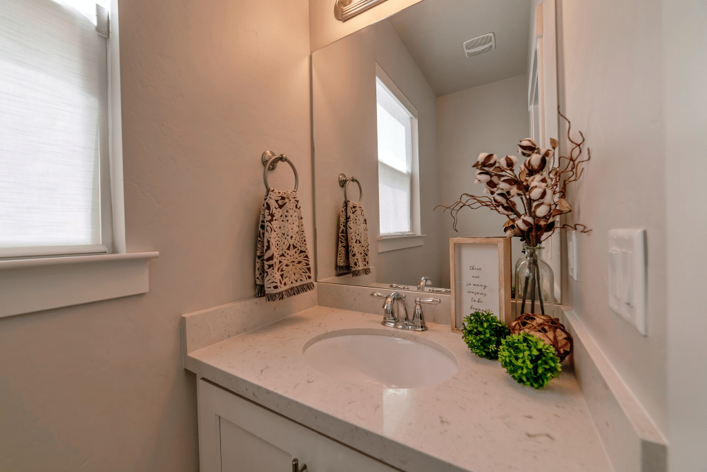 Oval undermount sink with polished chrome faucet installed in marble countertop bathroom vanity.