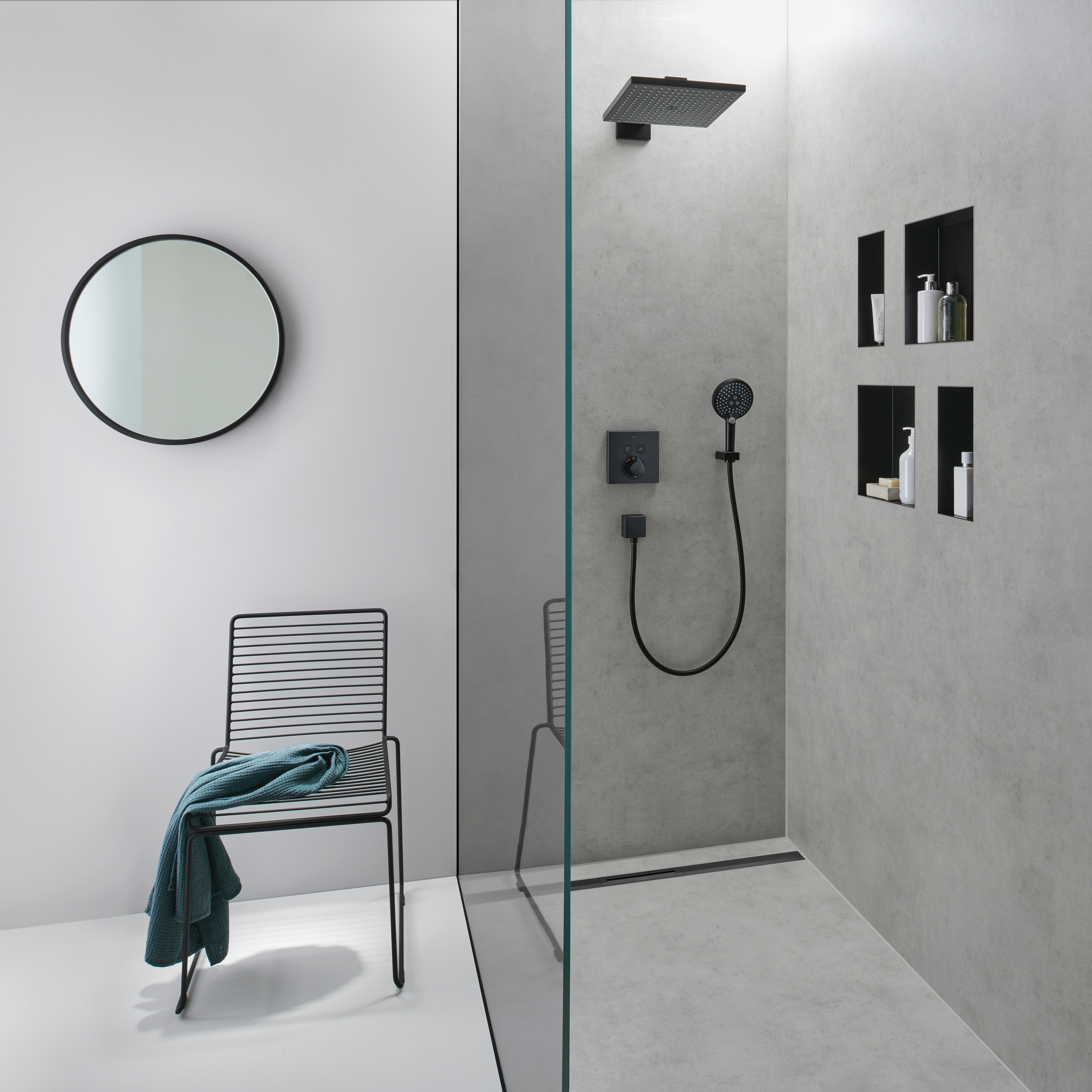 Matte black square wall niche with open frame mounted in shower enclosure, displaying bathroom accessories and bottles.