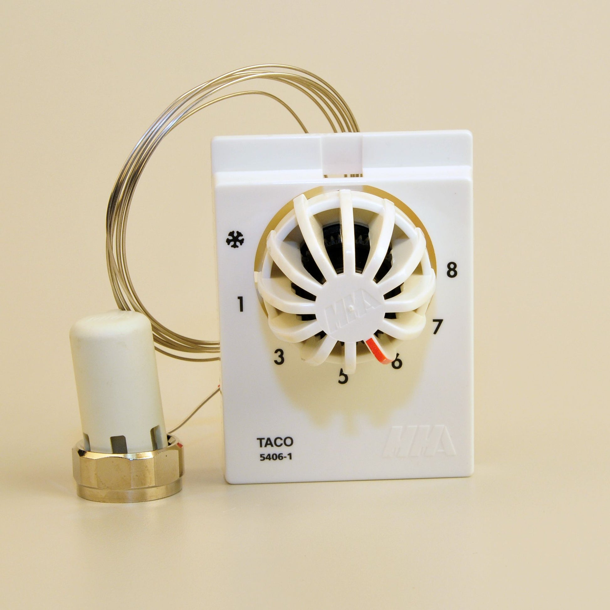White wall-mounted dial operator with numbered settings 1-8, brass sensor bulb, and connected tubing.