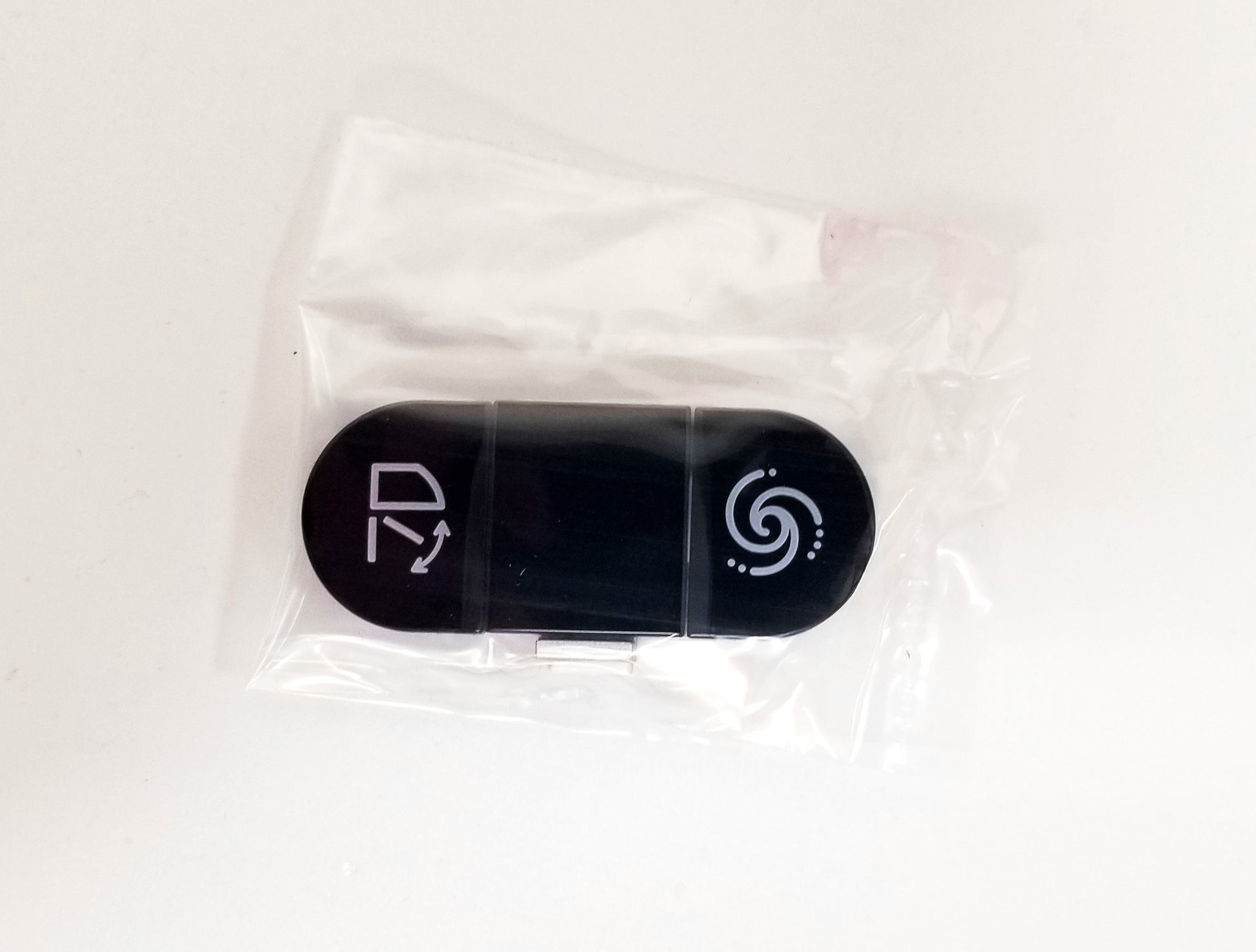 Black oval replacement button with two function icons: toilet seat symbol on left, water spray symbol on right.