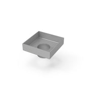 Square stainless steel drain with center opening and satin finish surface.