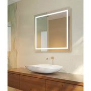 Square lighted mirror with white frame mounted above vessel sink on wooden vanity.