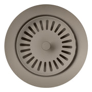 Truffle-colored circular metal waste flange with radial slot pattern and center knob, top view.
