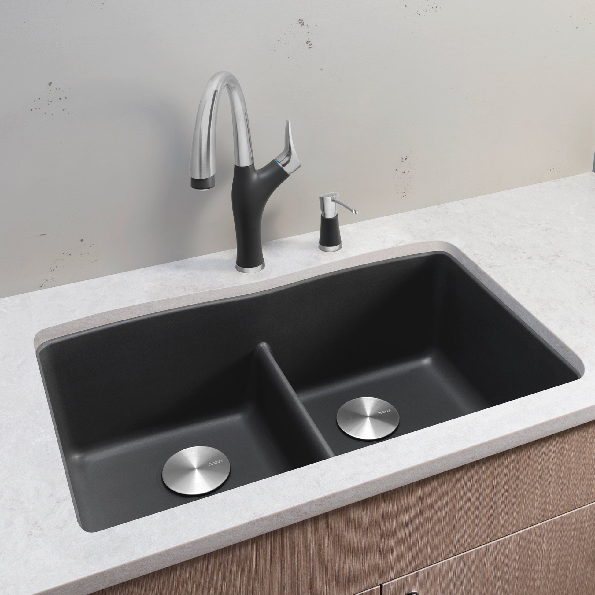Dark gray undermount double kitchen sink with equal basins, low divider, and stainless steel drain covers installed in white 