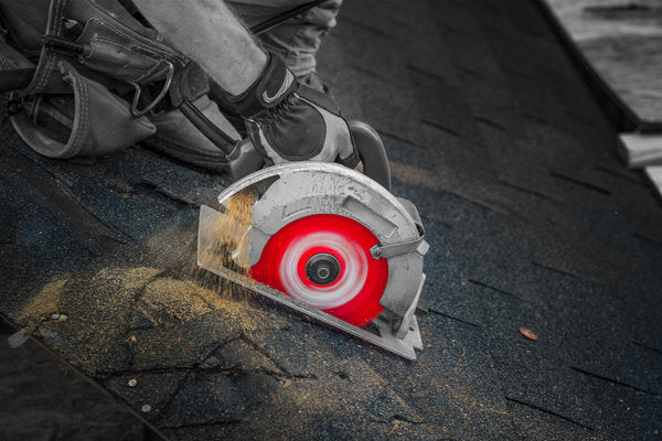 Circular saw blade with 24 teeth, red blade guard, and white housing cutting through dark roofing material.