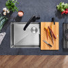 Ash and gray compound cutting board with two surfaces and integrated handles on wooden surface.
