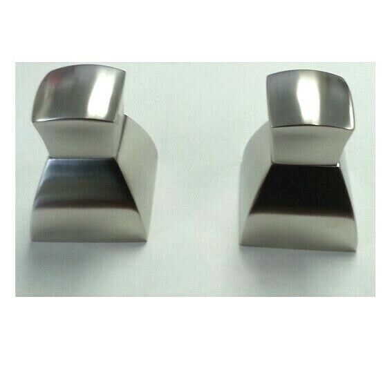 Chrome wall-mounted faucet handles with square bases and curved tops in brushed metal finish.