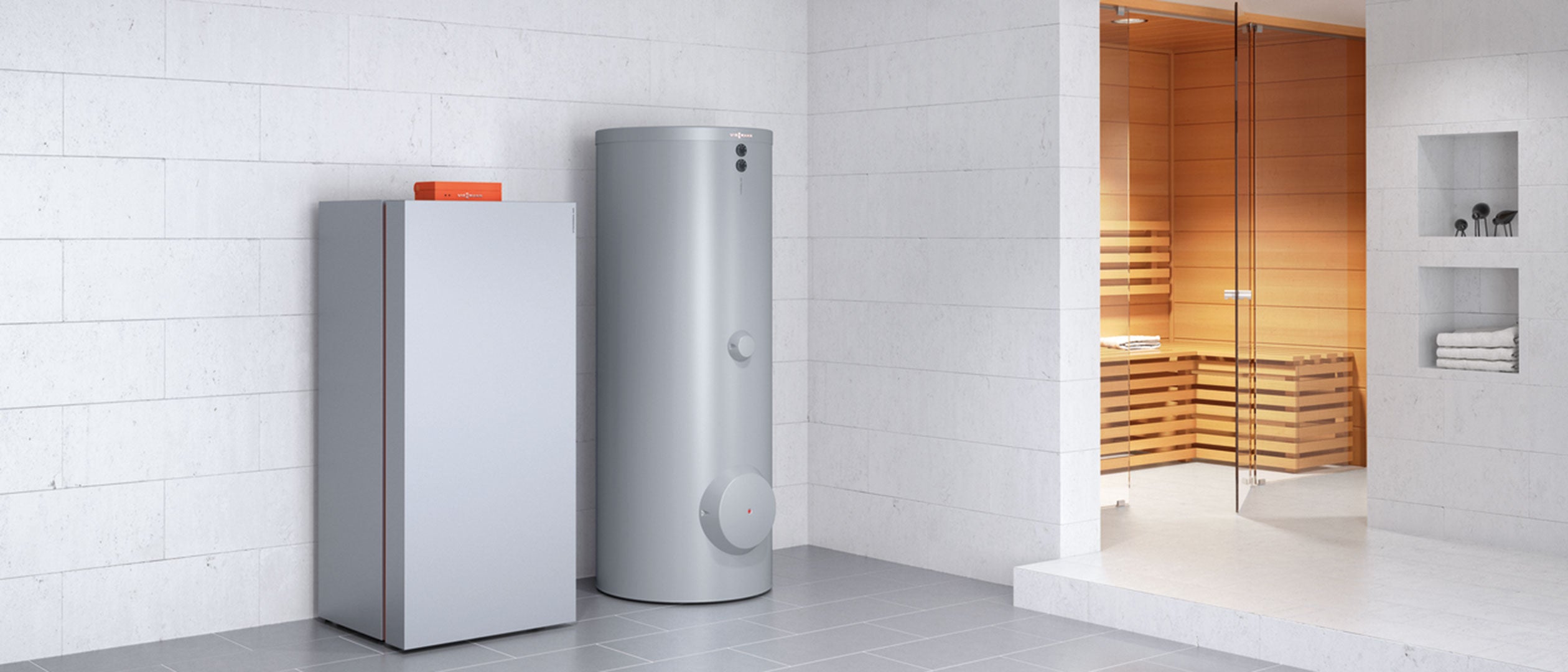 Silver cylindrical gas condensing boiler with control panel positioned next to rectangular unit in bathroom setting.