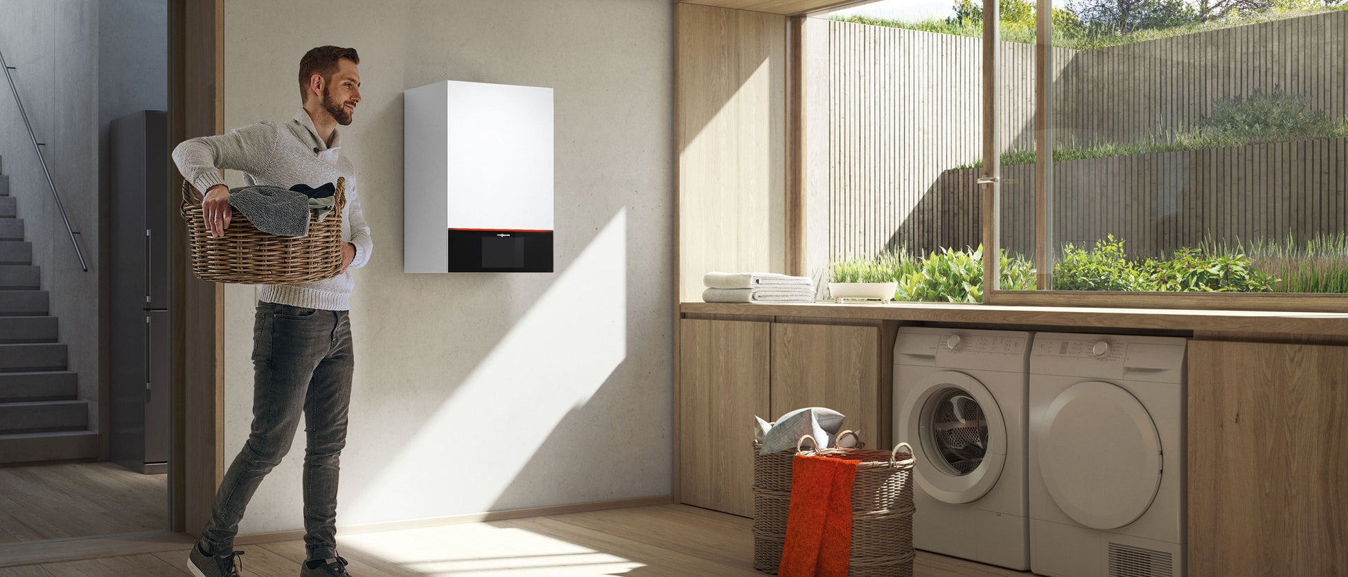 White and black wall-mounted hydronic boiler unit installed in a laundry room above wooden cabinetry.