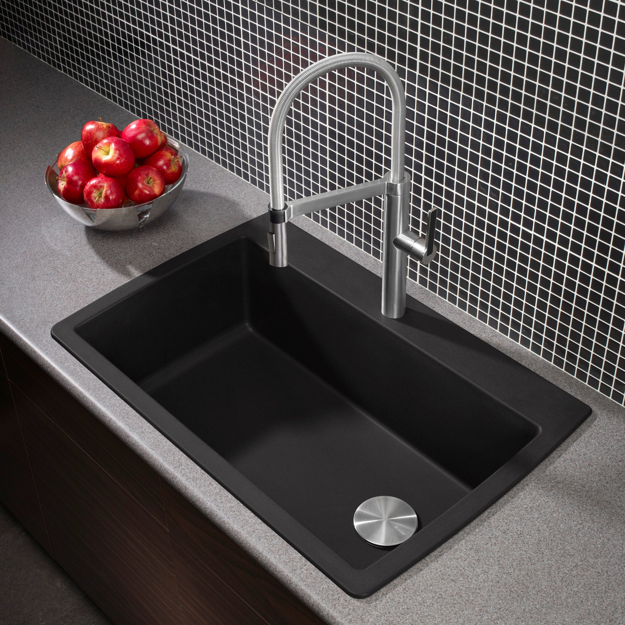 Anthracite single bowl kitchen sink with stainless steel pull-down faucet installed in gray countertop with small tile backsp