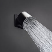 Matte black cylindrical shower head mounted on wall bracket with water stream flowing downward.
