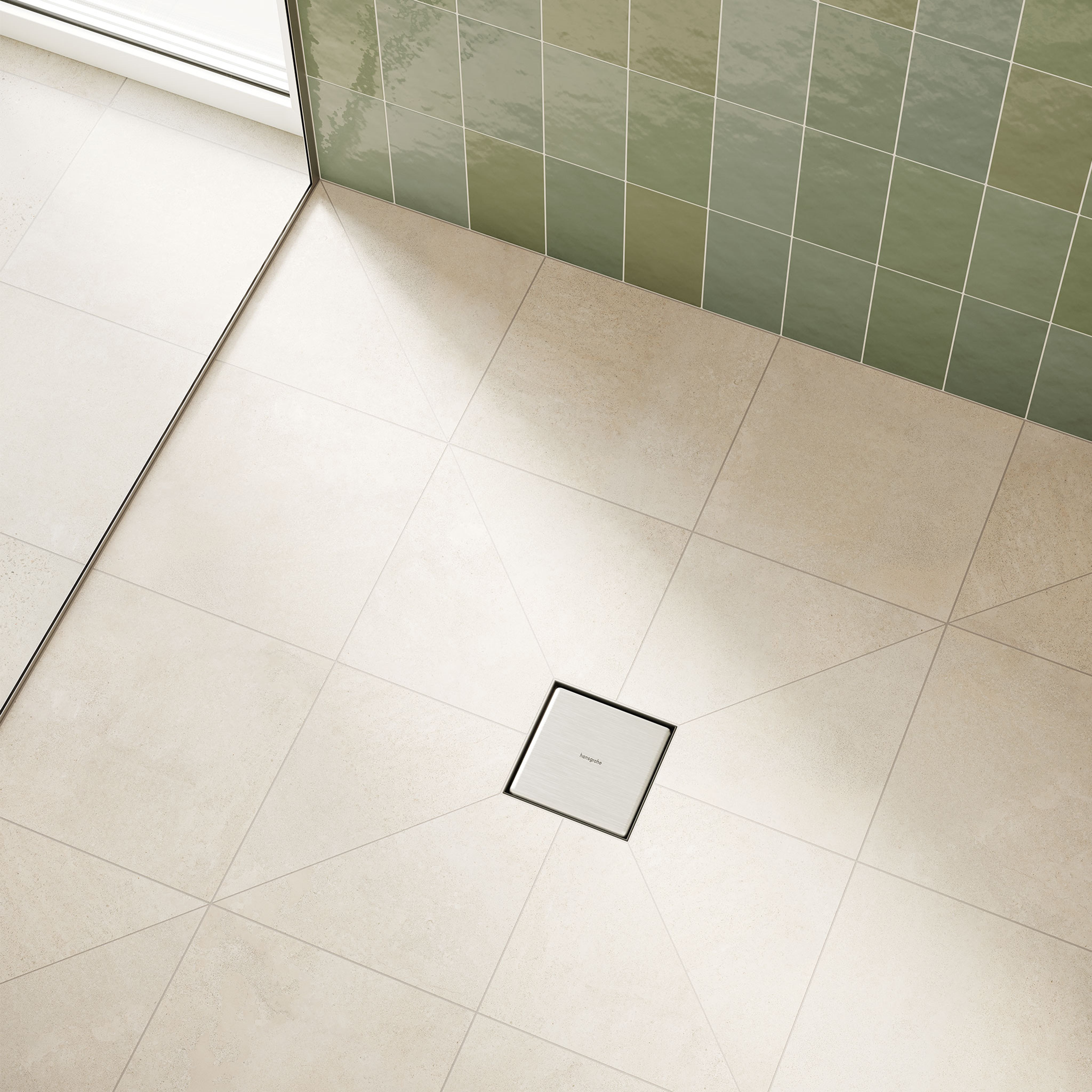 Square stainless steel floor drain with black trim installed in tiled shower floor next to green tile wall.