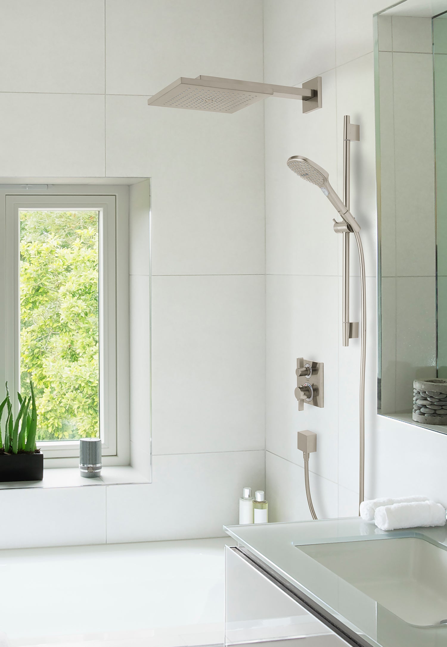 Brushed nickel thermostatic shower system with overhead rainfall head, handheld wand, and wall-mounted controls in bathroom s