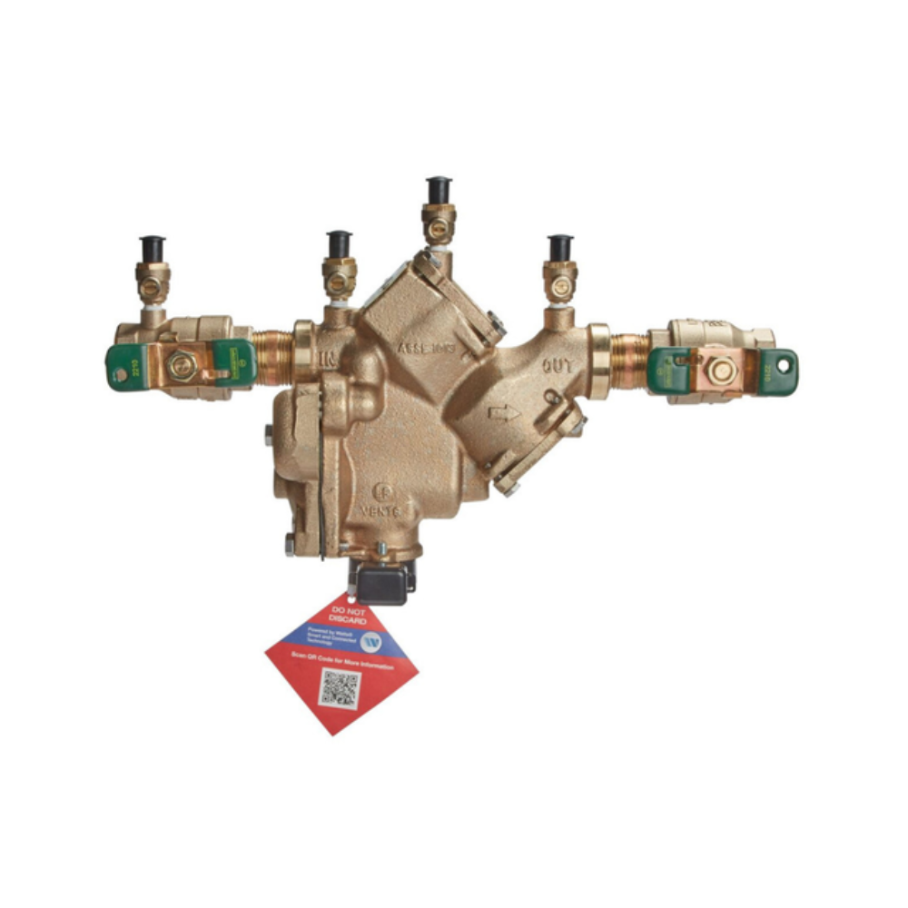 Bronze backflow preventer with symmetrical ports, green shutoff handles, and red product label attached.
