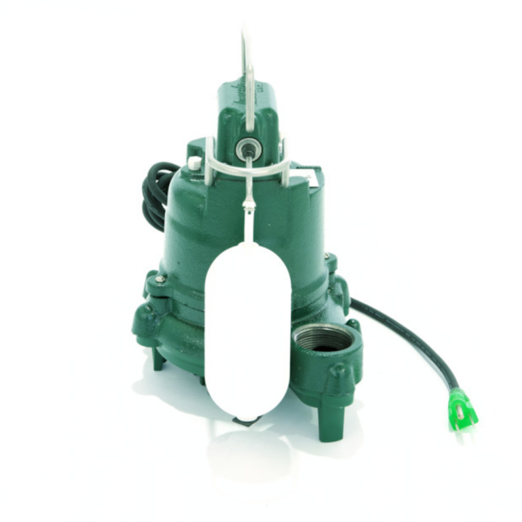 Green cast iron sump pump with white float switch arm and power cord attached.