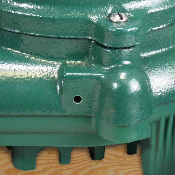 Green cast iron sump pump body with intake ports and discharge connection visible from above.