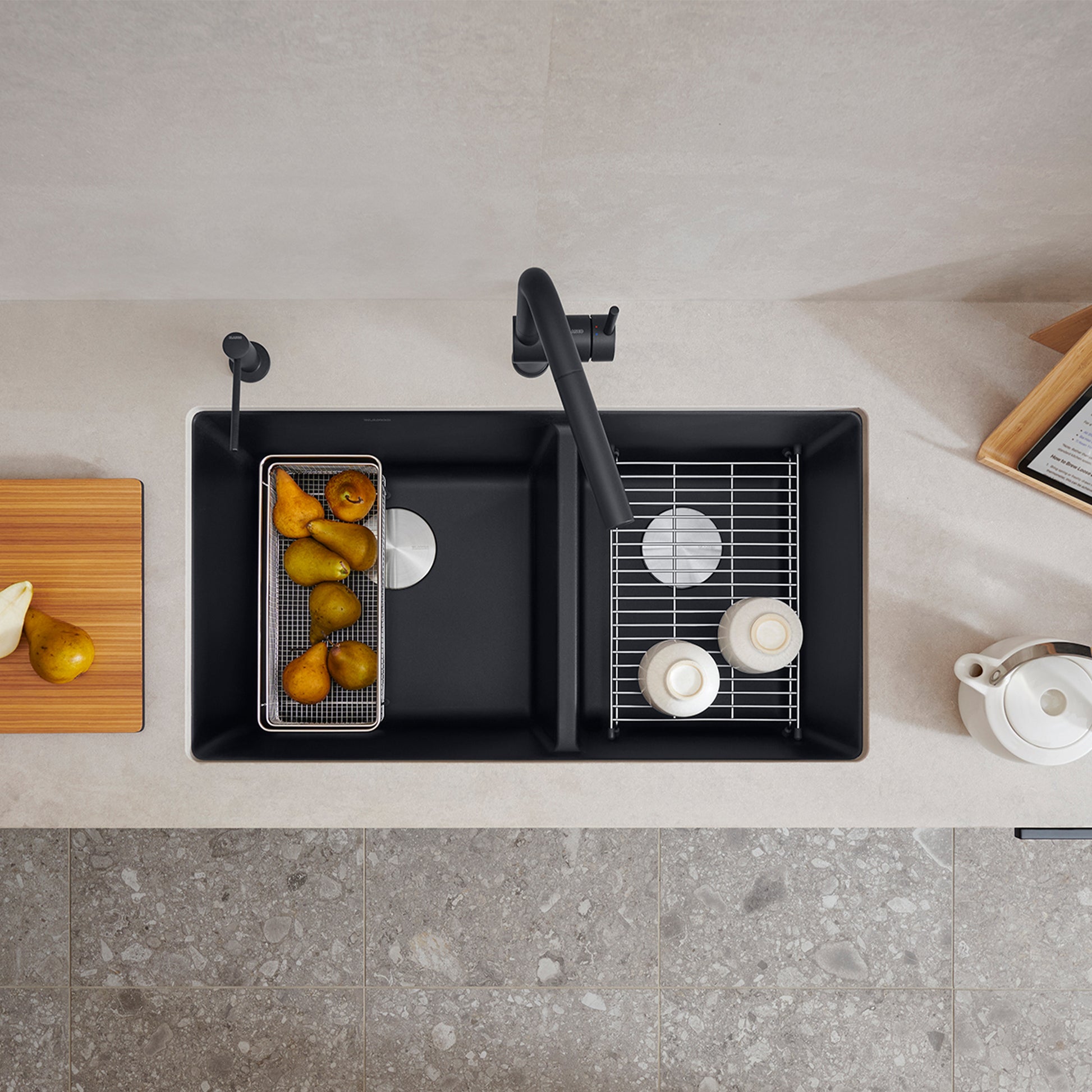 Coal black 60/40 double bowl undermount kitchen sink with two grid inserts and black faucet, viewed from above.
