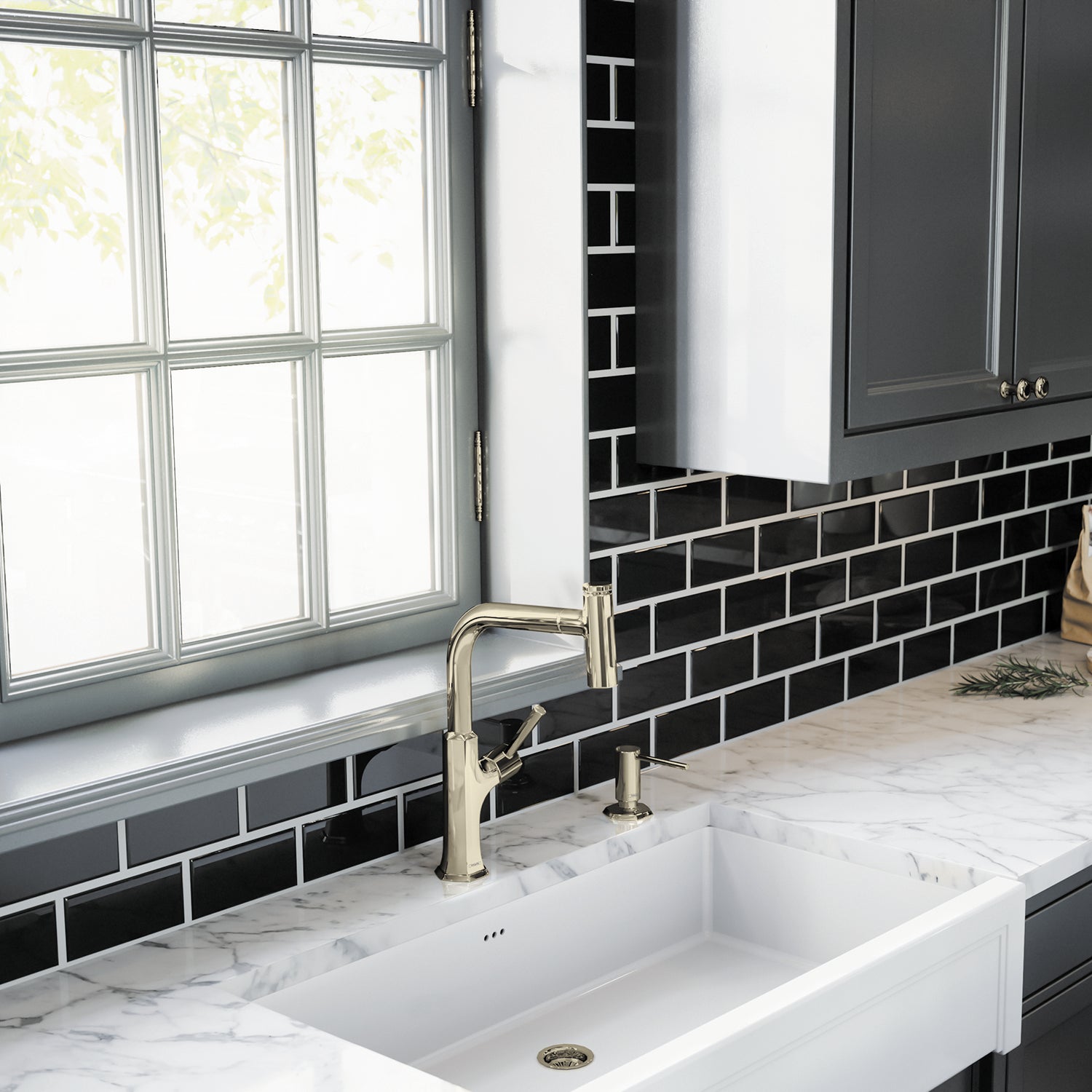 Polished nickel soap dispenser pump mounted on white marble countertop next to kitchen sink.