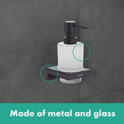 Matte white cylindrical soap dispenser with black metal pump mounted on dark wall shelf.