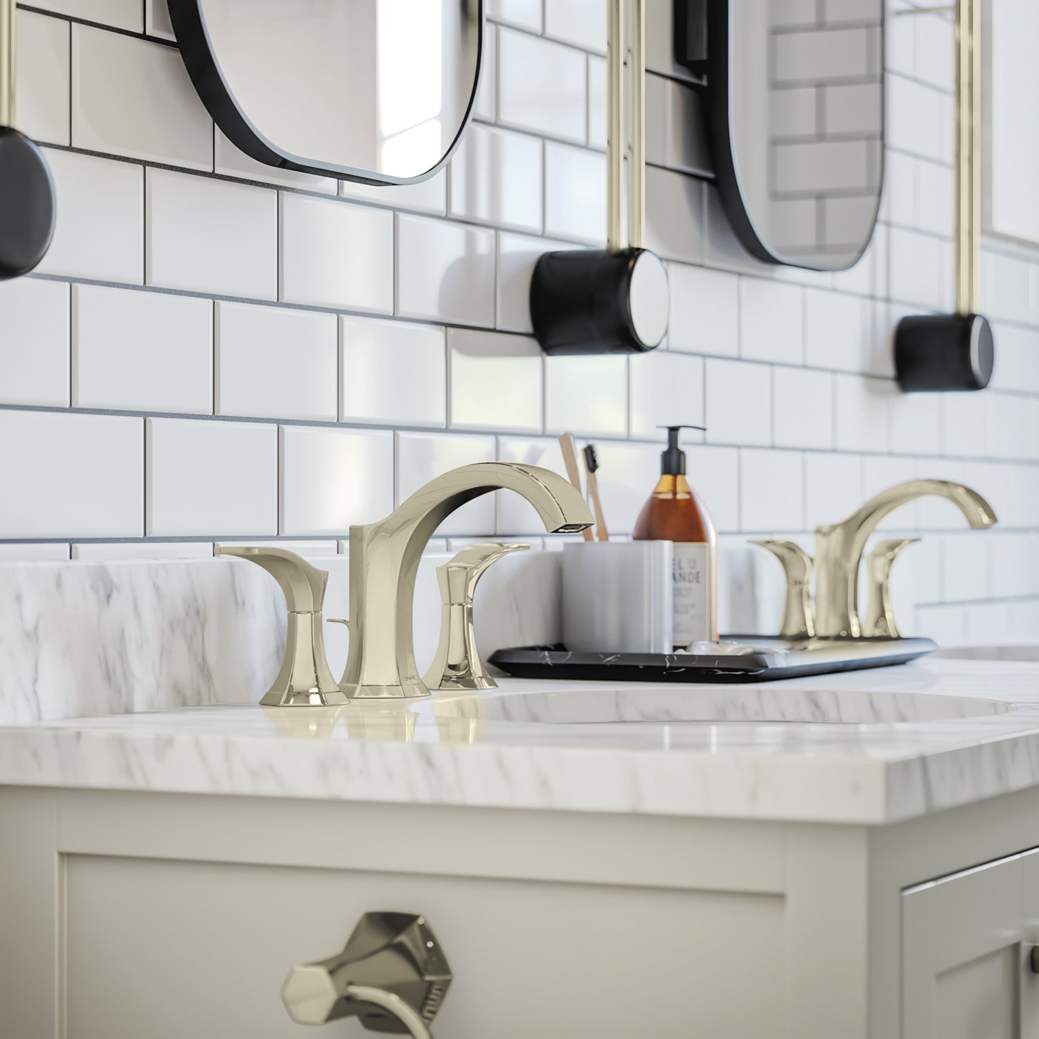 Polished nickel widespread bathroom faucet with curved handles and pop-up drain installed on marble vanity.