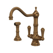 English bronze two-handle kitchen faucet with curved spout and matching side spray, ornamental handles and base.