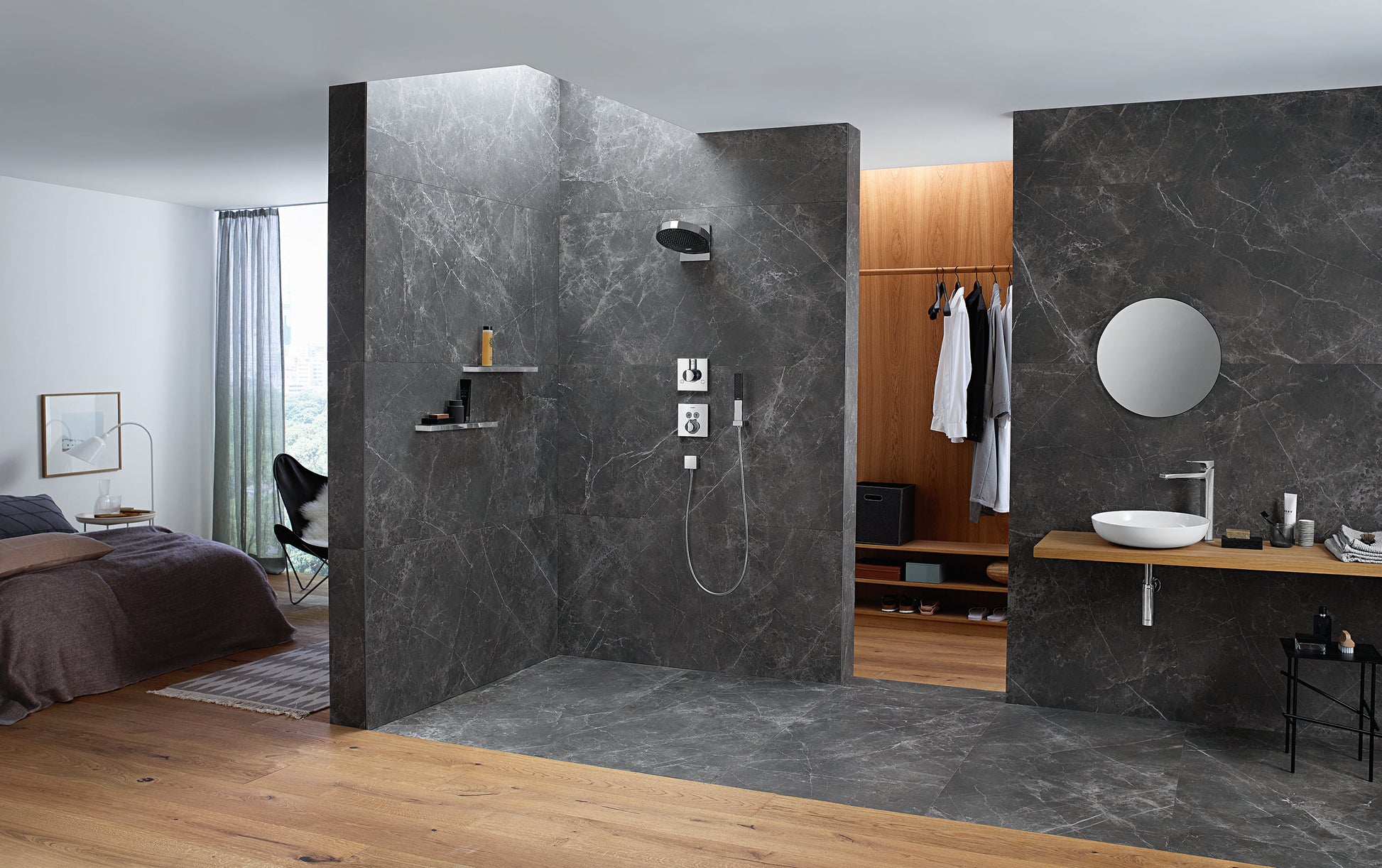 Matte black round shower head mounted on dark marble wall in modern bathroom with wooden vanity.