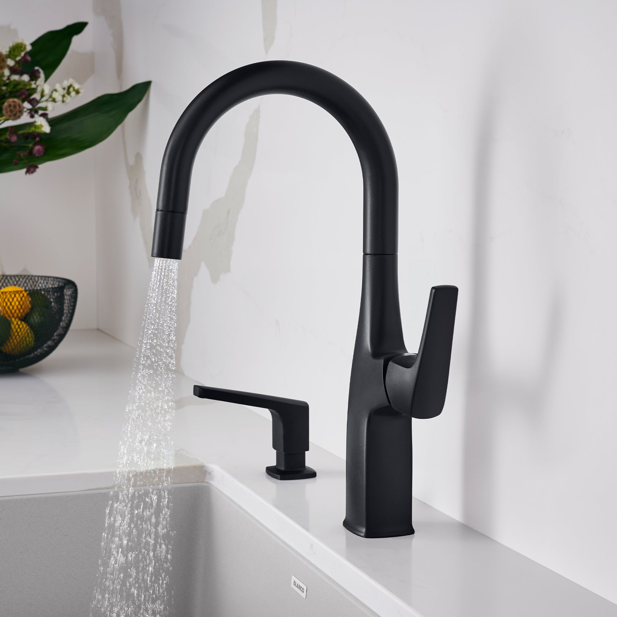 Matte black bar faucet with curved spout, single handle, and soap dispenser mounted on white countertop.