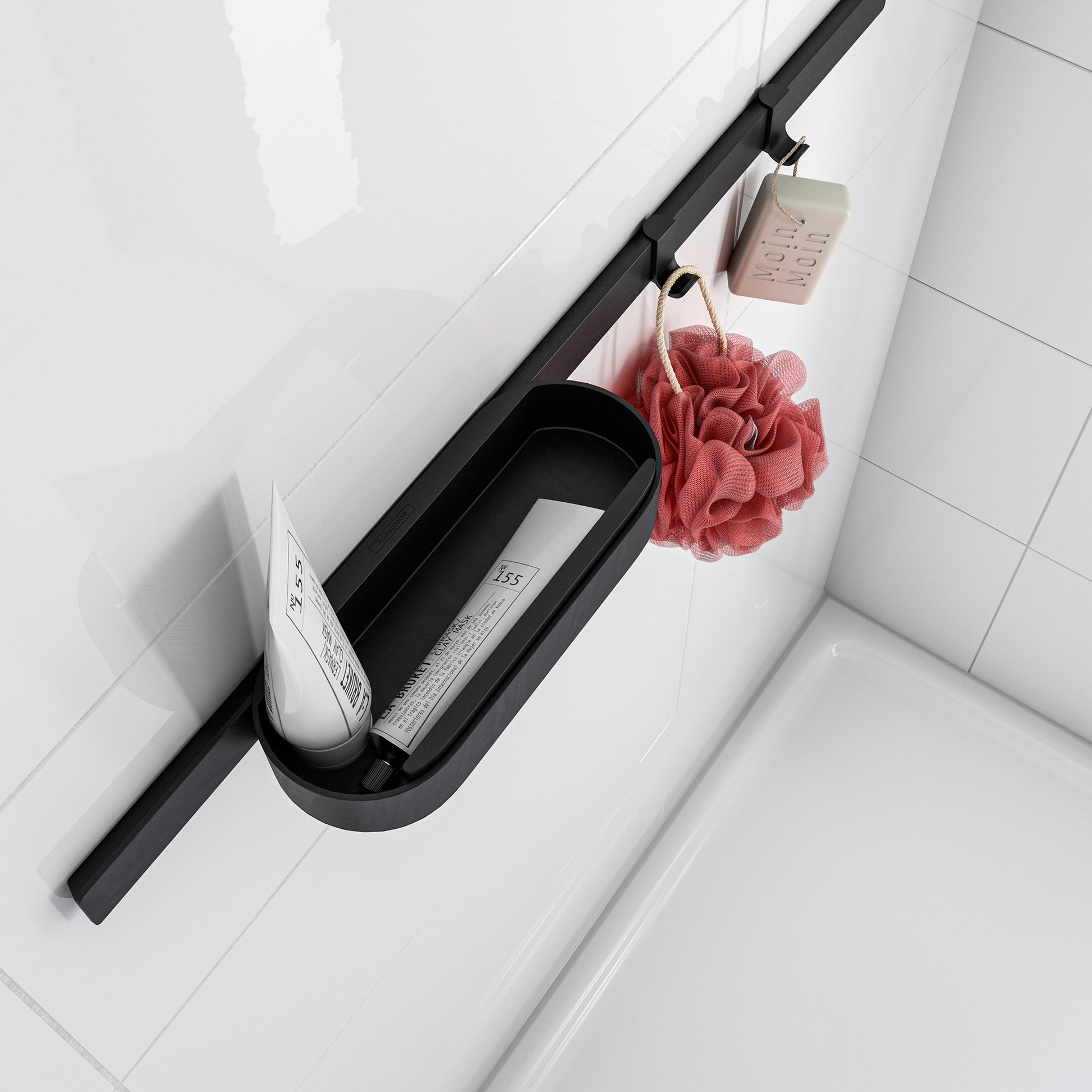 Matte black wall-mounted towel hook with wide curved design holding a bath sponge and soap.