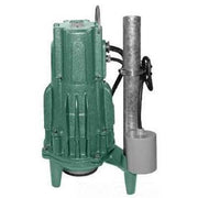 Green Zoeller grinder pump with gray discharge pipe and black valve handle on white background.