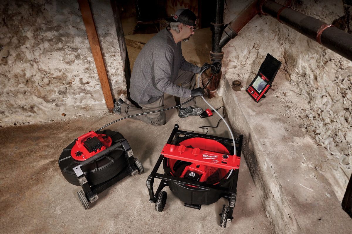 M18 FUEL™ High Speed Chain Snake for 1-1/2” – 4” Pipes A man kneeling down over a basement drain using the M18 FUEL™ High Speed Chain Snake for 1-1/2” – 4” Pipes to clean it