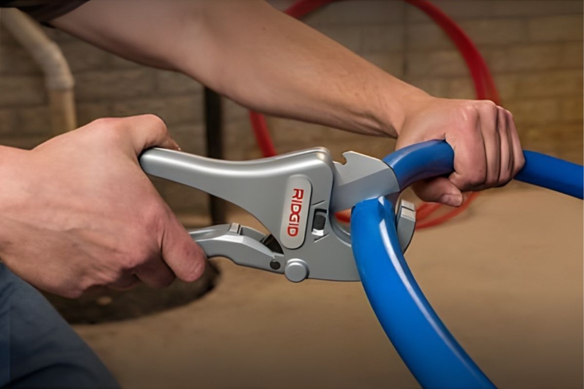 RC-2375 2" Ratchet Action Plastic Pipe and Tubing Cutter A hand holding a pipe and cutting it by using the RC-2375 2" Ratchet Action Plastic Pipe and Tubing Cutter