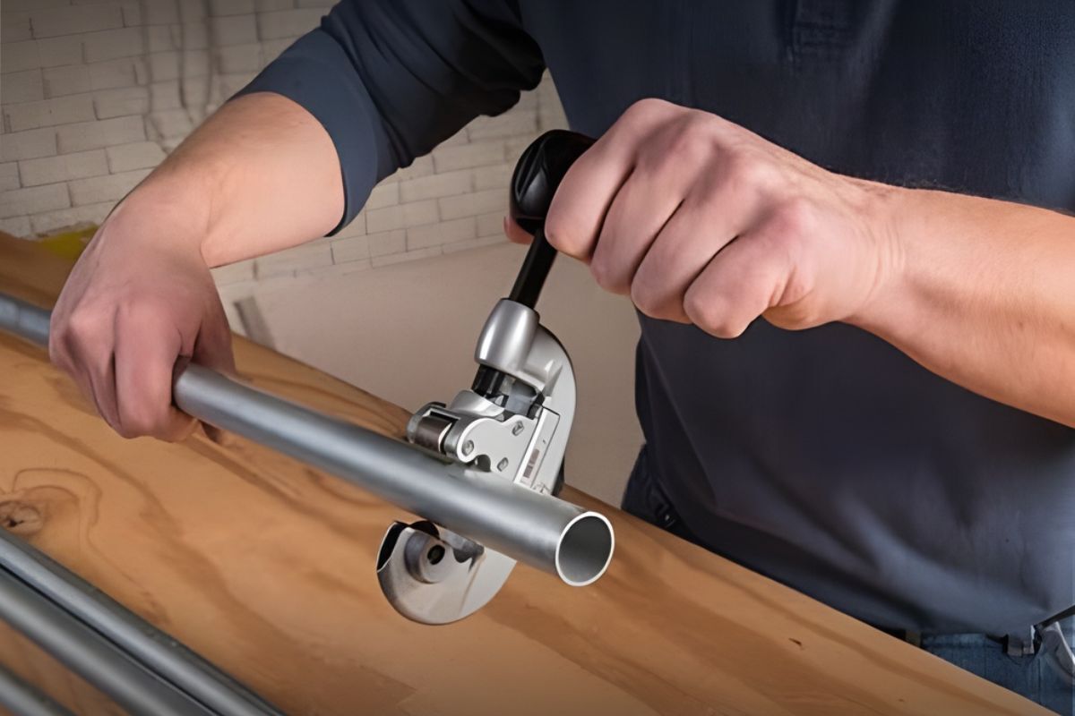 RIGID Quick-Acting Tube Cutter A hand holding a pipe and cutting it by using the RIGID Quick-Acting Tube Cutter